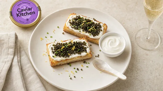 Two slices of buttered toast topped with crème fraîche, chives, and Huso Dauricus caviar on a white ceramic plate